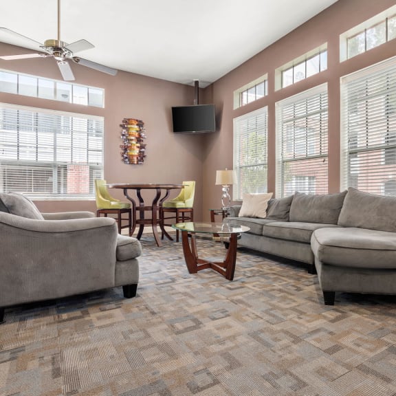 a living room with couches and chairs and large windows at Veranda at Centerfield in TX 77070