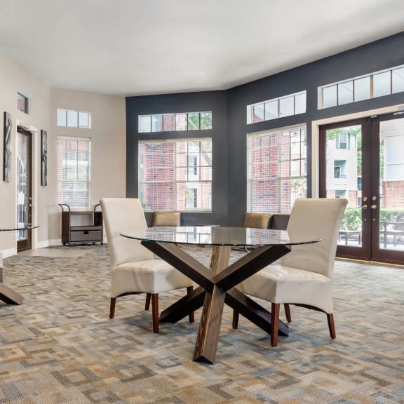 a dining room with a glass table and chairs and windows at Veranda at Centerfield in Texas 77070