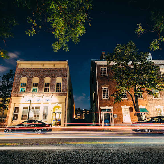 A street view of a city with cars parked on the side of the road.