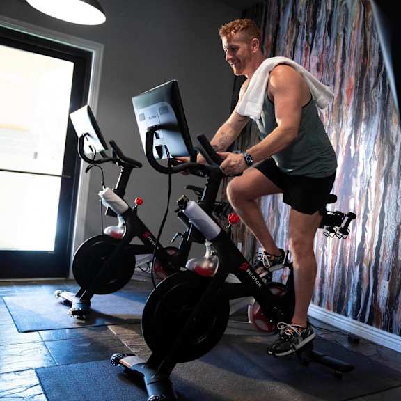 A man is working out on a stationary bike in a gym.