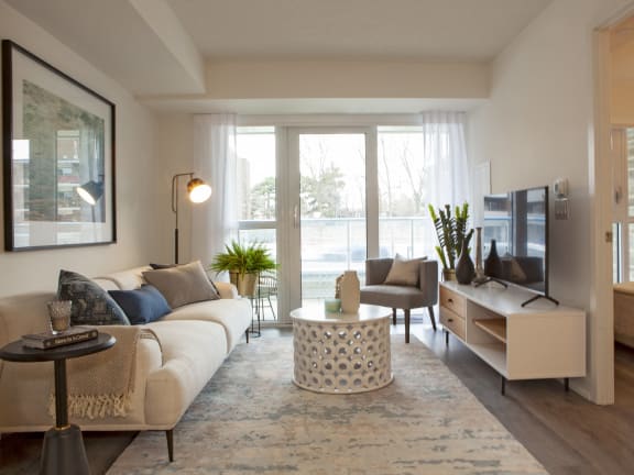 a living room with a couch and a tv in front of a window