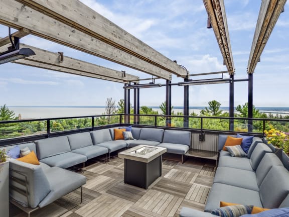 a rooftop patio with couches and a table  at Bluestone Flats, Duluth, MN