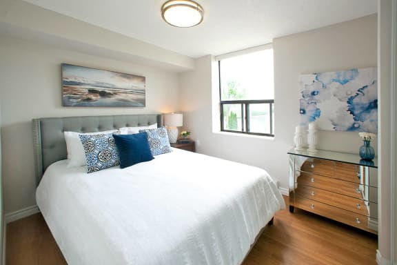 a bedroom with a bed and a dresser and a window