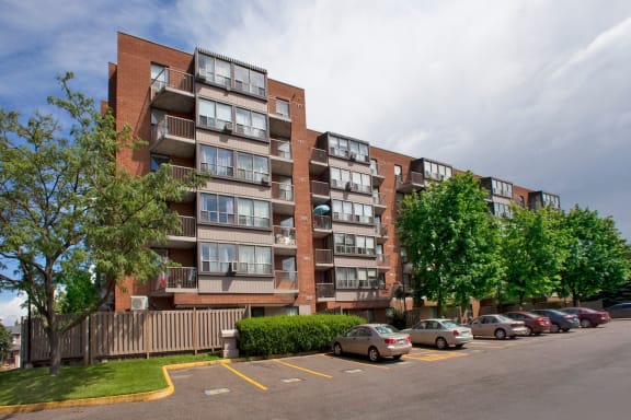 an apartment building on a street with cars parked in front of it