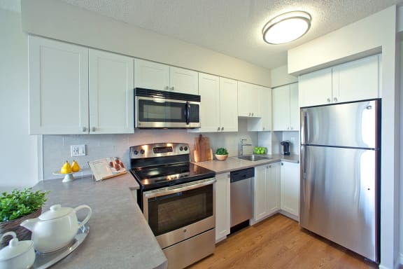 a kitchen with stainless steel appliances and white cabinets