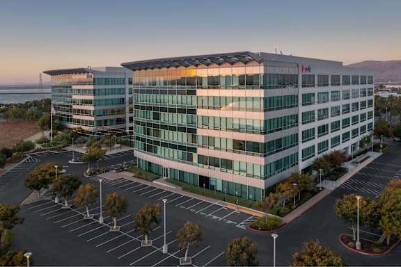 A modern building with a parking lot in front of it.