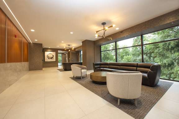 a lobby with couches and chairs and large windows