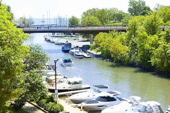 a marina filled with boats on a river under a bridge