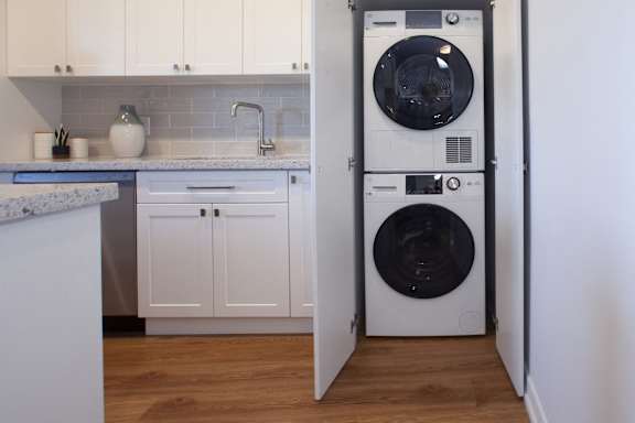 a white kitchen with a washing machine and a washer and dryer