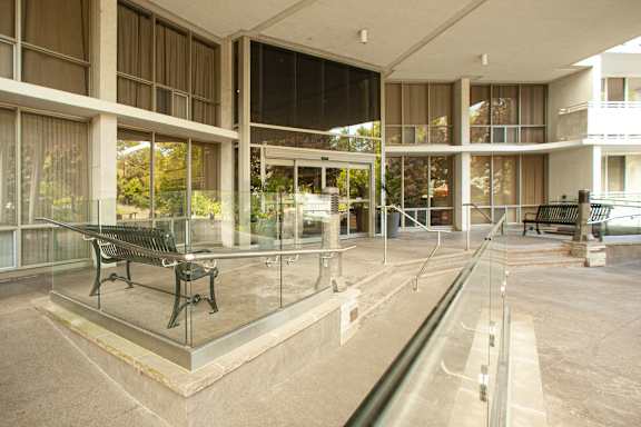 the lobby of a building with a glass table and chairs