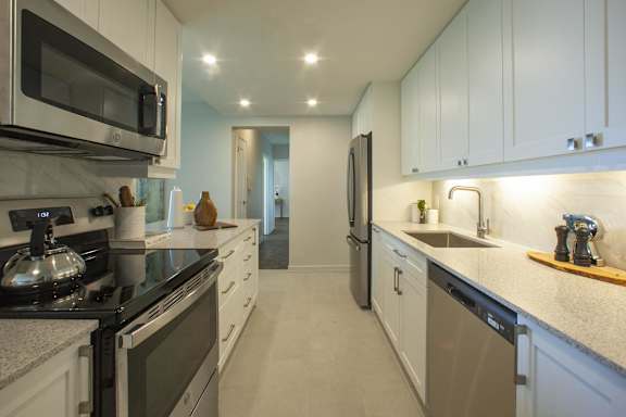 a kitchen with white cabinets and granite counter tops and a black stove