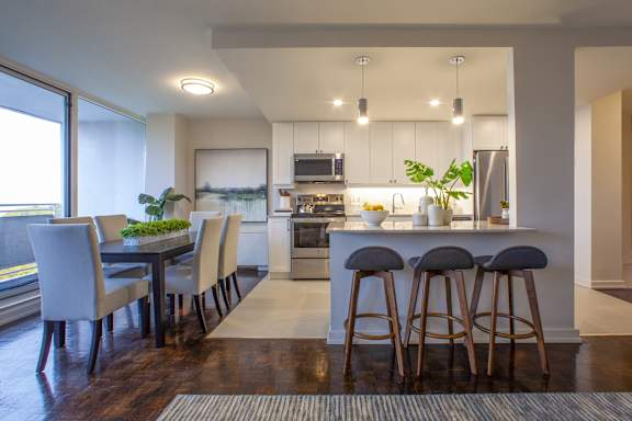 a kitchen and dining room with a bar and stools