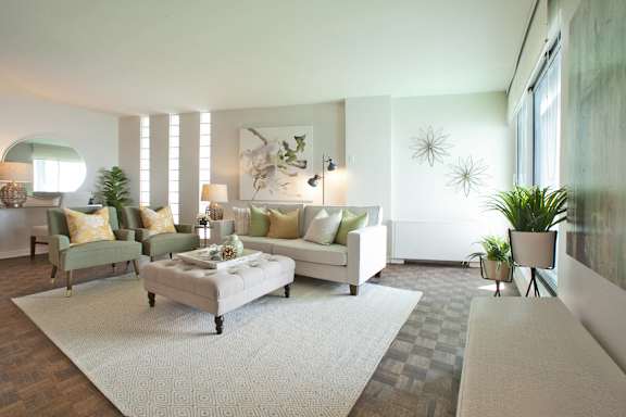a living room with white furniture and a rug