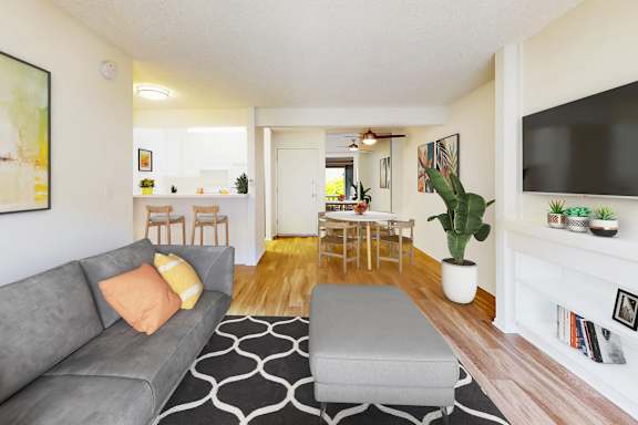 A living room with a grey couch and a black and white rug.