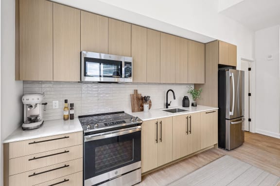 a kitchen with wooden cabinets and stainless steel appliances