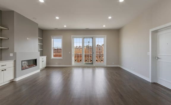 an empty living room with a fireplace and a window