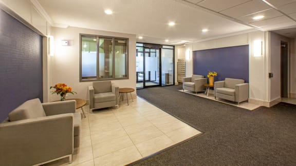 a lobby with couches and chairs and a blue wall