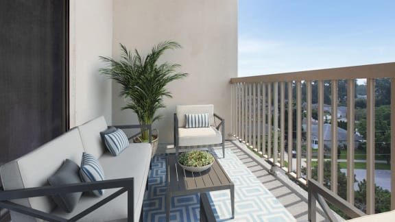 a balcony with a couch and chairs and a potted plant