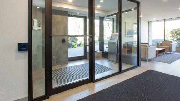 a lobby with glass doors and a exit sign