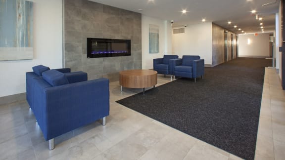 a lobby with blue couches and chairs and a television