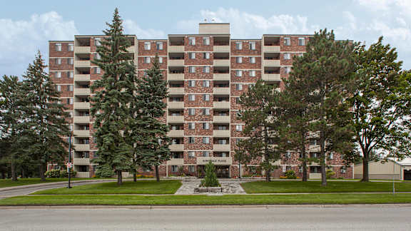 an apartment building on the corner of a street with trees