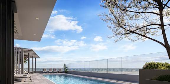 A modern pool area with a clear blue sky.
