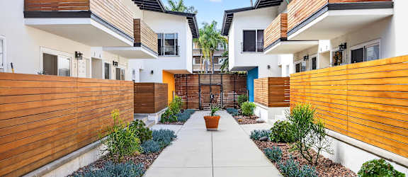 A modern residential area with a central walkway and houses on either side.