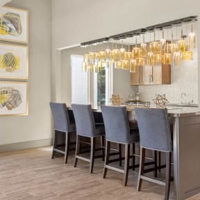 a kitchen with a bar with chairs and a chandelier