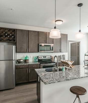 a kitchen with stainless steel appliances and a granite counter top at Village at Westland Cove Apartments, Tennessee