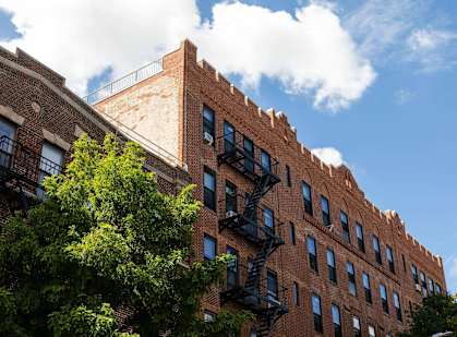 A red brick building with a fire escape on the side.