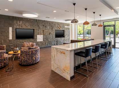 A modern living room with a stone wall and a bar area.