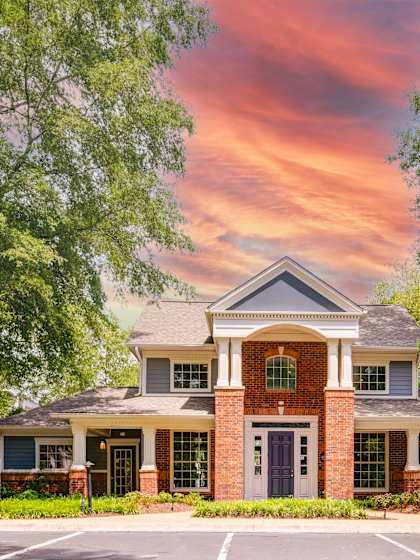A house with a red brick front door and a large front porch.