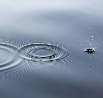 a water droplet making a ripple in a body of water