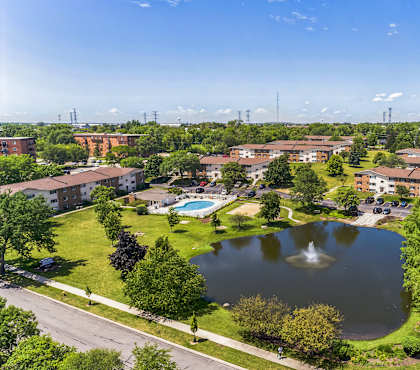 an aerial view of a pond in the middle of a community with buildings at St Charles Square Apartments, Carol Stream, IL, 60188