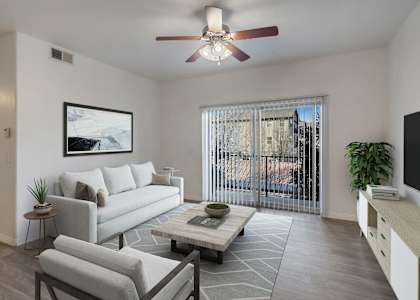 A living room with a grey couch, a coffee table, and a ceiling fan.at Florentine Villas, Utah