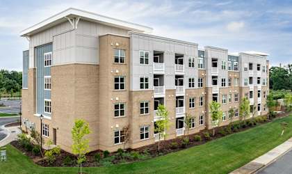 A large apartment complex with multiple buildings and green lawns in front.