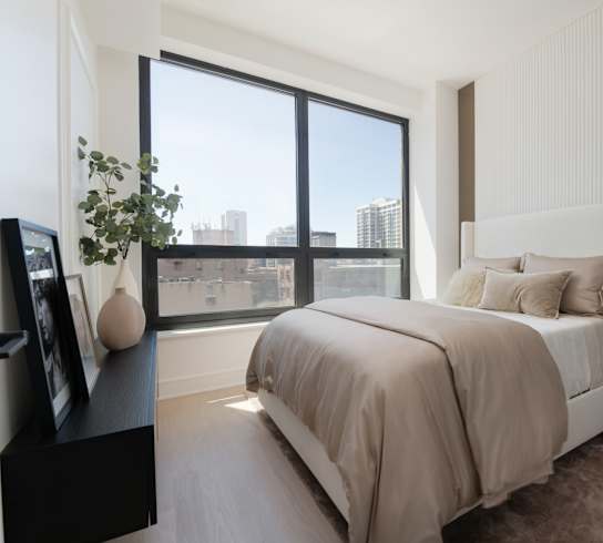 a bedroom with a large window and a bed at Chateau on Wells, Chicago, Illinois