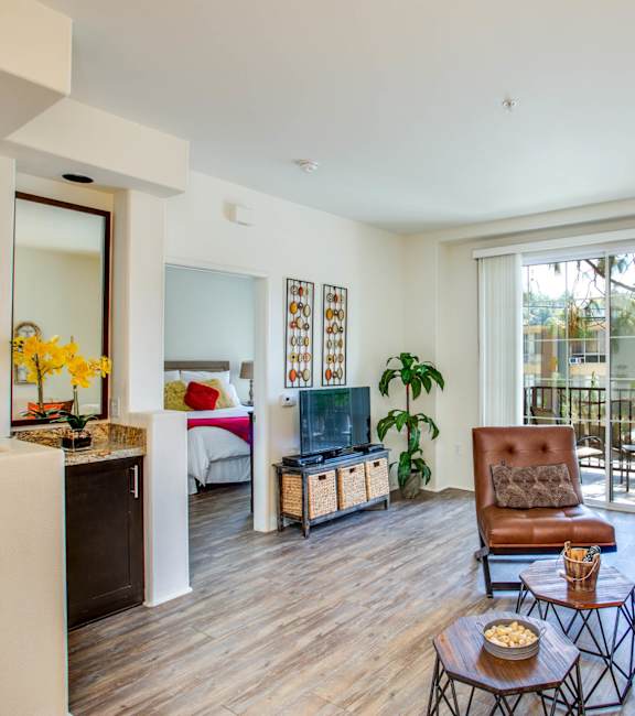 a living room with a couch and a tv and a balcony at L'Estancia, Studio City, CA, 91604
