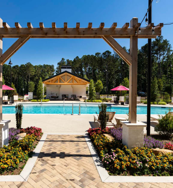 a swimming pool with a pool house in the background at The Quincy Apartments in Acworth, Georgia 30102