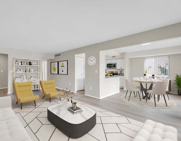 A modern living room with a white sofa, yellow chairs, and a coffee table.