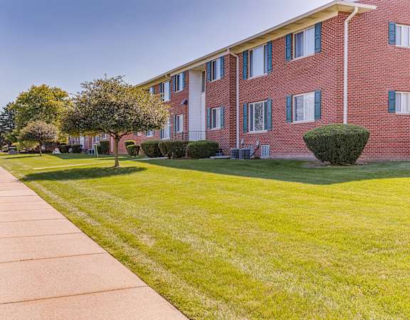 A red brick building with a green lawn in front.