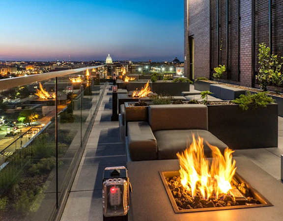 a fireplace on a rooftop overlooking a city at night