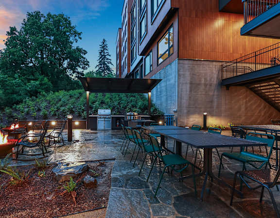 Covered BBQ area with nearby firepit lounge - Willow Apartments