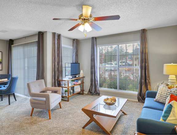 a living room with a couch and a table and a ceiling fan
