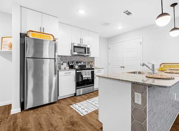 A kitchen with a refrigerator, oven, and microwave.