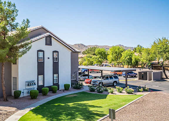 A white house with a grey roof and a green lawn in front at Sterling Point Apartment Homes, Phoenix, AZ, 85042