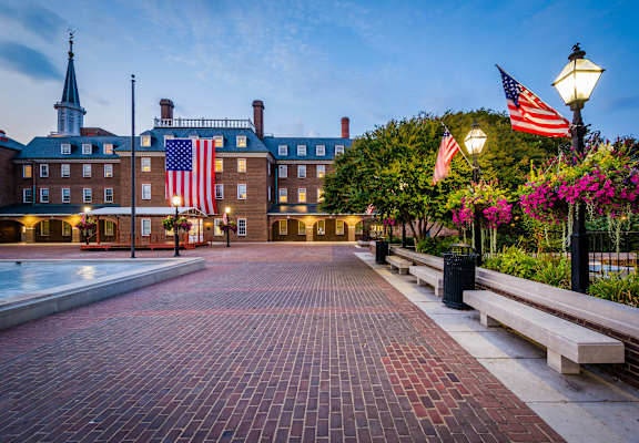 A brick walkway leads to a building with an American flag on it.
