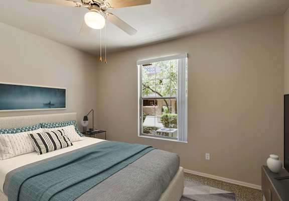 A bedroom with a bed, a ceiling fan, and a window. at Superstition Canyon Apartments, Arizona