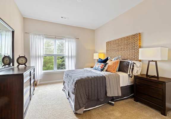 a bedroom with a bed and a dresser and a window