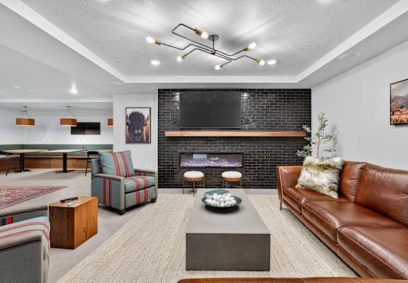 A modern living room with a fireplace and a flat screen TV mounted above it.